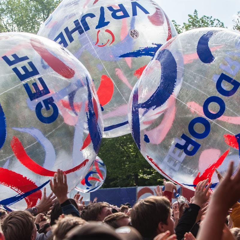 Een foto van strandballen die worden rondgegooid door veel publiek bij een festival